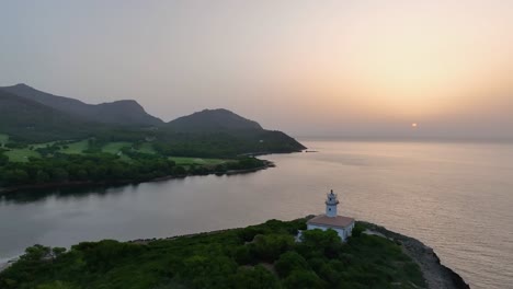 Sunrise-over-sea-next-to-lighthouse-on-small-island