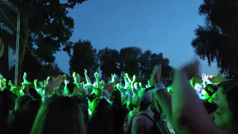 Riga,-Lettland---14.-Juli-2023:-Nicht-Wiederzuerkennende-Fans-Tanzen-Mosh-Pit-Und-Heben-Die-Hände-Bei-Einem-Konzert-Oder-Einer-Festivalparty.-Silhouetten-Eines-Publikums,-Das-Das-Konzert-Vor-Hellen-Bühnenlichtern-Genießt