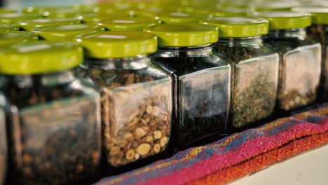 Various-seeds-and-spices-in-jars,-4k,-slomo