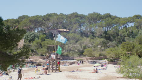 Un-Día-Soleado-En-La-Playa-De-Cala-Mondrago-En-Mallorca,-España,-Con-Gente-Descansando-Y-Disfrutando-De-La-Arena-Fina-Y-El-Agua-Cristalina
