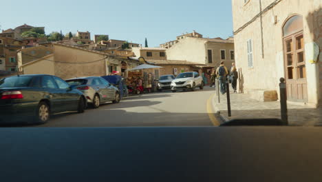 Eine-Belebte-Straße-In-Deía,-Palma-De-Mallorca,-Voller-Fußgänger-Und-Autos,-Die-Das-Geschäftige-Treiben-Eines-Späten-Nachmittags-Einfangen