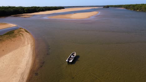 Drone-shot-following-a-small-motorboat-driving-slowly-through-shallow-waters-at-the-Apipé-Islands-in-Corrientes,-Argentina