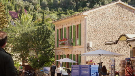 A-street-in-Deía,-Mallorca,-Spain,-animated-with-tourists,-and-a-house-in-the-background-adding-to-the-local-charm