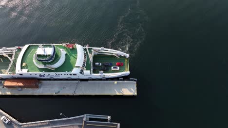 Electric-car-and-passenger-ferry-named-Dragsvik-is-alongside-Vangsnes-in-Sognefjord-Norway---Top-down-birdseye-aerial