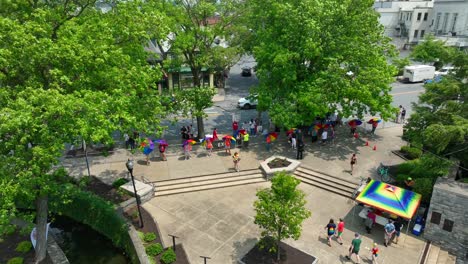 Drone-view-of-a-community-gathering-at-a-park-preparing-for-a-pride-festival-on-a-sunny-summer-day