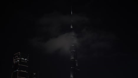 Clouds-pass-by-the-top-of-the-Burj-Khalifa-in-downtown-Dubai-at-night-time