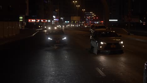 Busy-traffic-driving-in-downtown-Dubai-at-night-time-in-the-United-Arab-Emirates-in-slow-motion