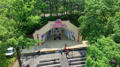 Drone-view-of-Lititz-Springs-Park-amphitheater-preparing-for-a-pride-festival-on-a-summer-afternoon