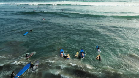 Overtourism-in-tropical-paradise,-crowd-of-surfers-on-Batu-Bolong-beach,-Bali,-Indonesia