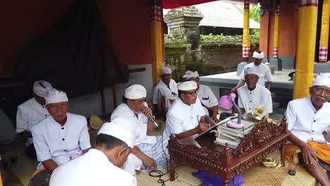 Balinesen-Lesen-Traditionelle-Heilige-Hinduistische-Texte-Bei-Der-Tempelzeremonie-In-Bali,-Indonesien,-Und-Tragen-Weiße-Kleidung