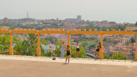 Schwenkaufnahme-Von-Touristen,-Die-An-Einem-Bewölkten-Tag-Den-Malerischen-Aussichtspunkt-Von-Der-Porto-Seite-Der-Vila-Nova-De-Gaia-über-Den-Fluss-Douro-In-Porto,-Portugal,-Genießen