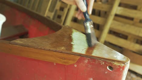 Brushing-varnish-over-plywood-on-fiberglass-canoe-Bow