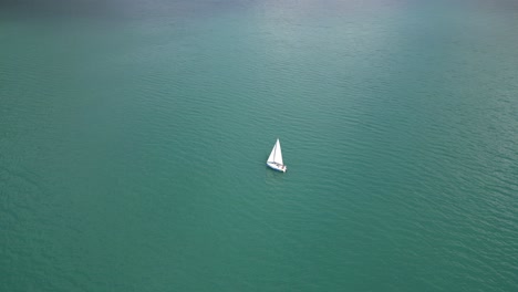 White-yacht-sailing-leisurely-in-vast-Switzerland-lake,aerial-view