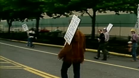 zoom-out-panning-shot-of-machinist-union-striking-with-signs-in-1980s-labor-port