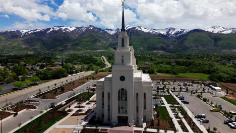 Flying-around-Layton-Temple-starting-at-front-moving-forward-and-off-to-right-seeing-full-side-as-well-as-beautiful-Wasatch-mountains-and-blue-sky