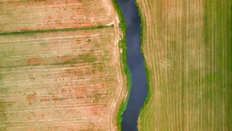 Aerial-view-of-a-winding-river-through-farmland