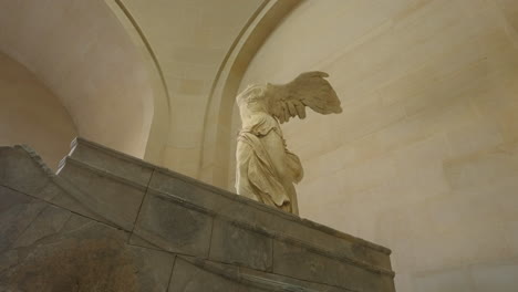 Toma-De-Establecimiento-De-Una-Estatua-De-Mármol-Femenina-Alada-Dentro-Del-Museo-Del-Louvre