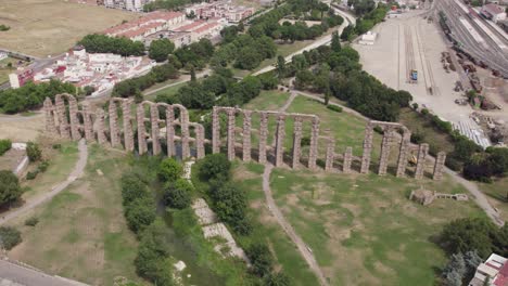 Aerial-orbit-around-old-roman-stone-aqueduct-ruins,-archaeology-in-Merida,-spain