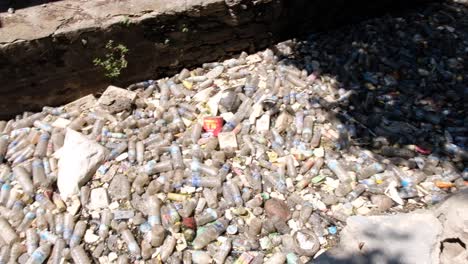 Plastic-waste-in-a-narrow-stream-stopped-from-polluting-the-ocean-by-gate-in-Southeast-Asian-destination