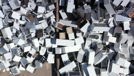 Aerial-ascent-above-massive-pile-of-white-discarded-appliances