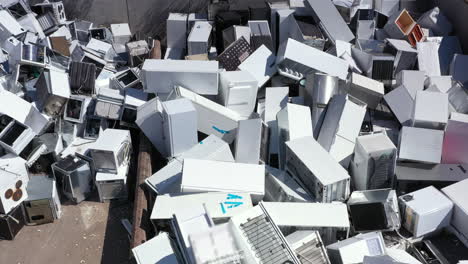 Aerial-pullback-view-of-discarded-household-appliances-dumped-at-landfill
