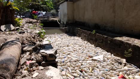Plastic-waste-polluting-stream-prevented-from-entering-the-ocean-in-capital-city-of-Dili,-Timor-Leste-in-Southeast-Asia