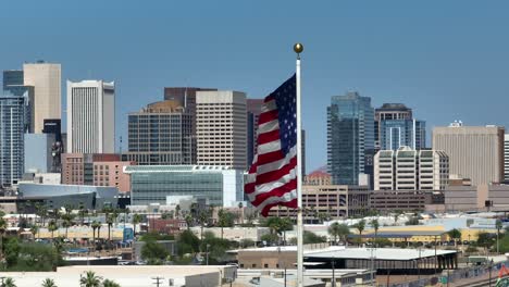 Phoenix,-Arizona-skyline-with-American-flag-waving-in-foreground