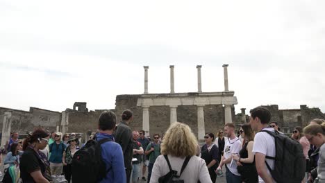 Grupo-De-Turistas-Escuchando-Al-Guía-En-Pompeya-Junto-Al-Foro-Di-Pompeya.