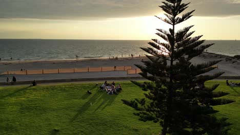 People-having-a-picnic-at-sunset-at-South-Beach-in-Fremantle,-Western-Australia