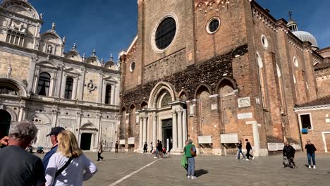 Kirche-San-Zanipolo-Und-Scuola-Grande-Di-San-Marco-Mit-Touristen,-Die-An-Der-Piazza-In-Venedig-Vorbeigehen