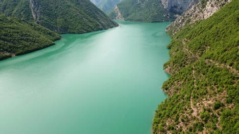 Albania,-the-green-waters-of-Lake-Koman-nestled-between-the-slopes-of-the-Accursed-Mountains