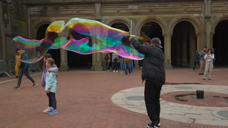 Man-entertains-making-large-bubbles-in-Central-Park-for-children
