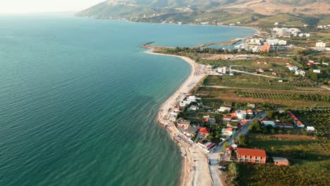 Albania,-beach-by-the-blue-Ionian-Sea,-with-mountains-in-the-background,-aerial-view-from-a-drone