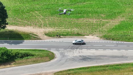 Vista-Aérea-De-Un-Dron-Quadcopter-Con-Cámara-Volando-Sobre-La-Carretera-Y-Observa-El-Tráfico-En-Un-Día-Soleado-De-Verano