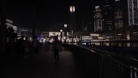 Menschenmassen,-Familien-Beim-Spazierengehen,-Einkaufen-Im-Dubai-Mall-In-Der-Innenstadt-Von-Dubai,-Vereinigte-Arabische-Emirate-Mit-Nachts-Beleuchteten-Wolkenkratzern-Und-Gebäuden
