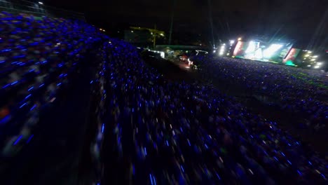 Flying-Above-Audience-Crowd-At-Night-Watching-Live-Concert-Of-Artist-Arcangel-At-Estadio-Quisqueya-In-Santo-Domingo,-Dominican-Republic