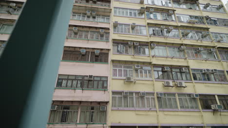 Spiegelung-Der-Skyline-Von-Hongkong-In-Den-Fenstern-Eines-Alten-Wohnhauses