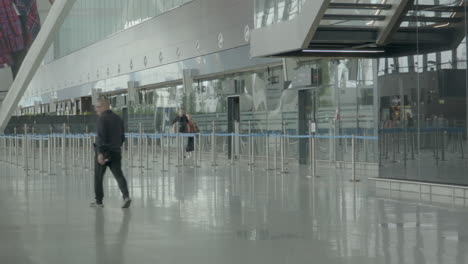 Few-People-Walking-At-The-Rope-Lanes-Near-Passenger-Terminal-Inside-The-Modern-Airport-In-Gdańsk,-Poland