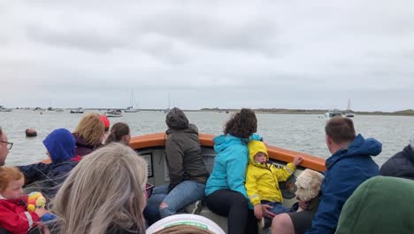 Boat-full-of-people-on-a-seal-tour-in-Blakeney-Point,-north-Norfolk