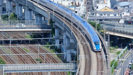 Shinkansen-train-riding-along-railroad-tracks