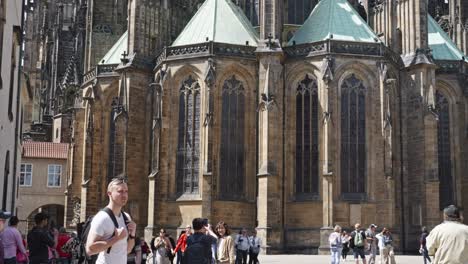 people-under-the-majestic-wall-of-Metropolitan-Cathedral-of-Saints-Vitus,-Wenceslaus-and-Adalbert-a-Roman-Catholic-metropolitan-cathedral-in-Prague,-Czech-Republic