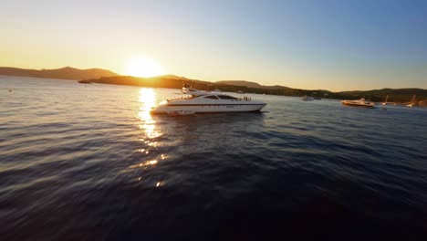FPV-aerial-drone-flying-over-the-water-toward-a-picturesque-Ibiza-sunset