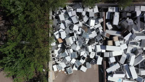 Heaps-of-broken-discarded-household-appliances-dumped-at-disposal-center,-aerial