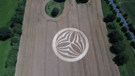 Descending-aerial-view-above-Warminster-crop-circle-2023,-mysterious-symmetrical-alien-pattern-on-harvested-corn-field-in-England
