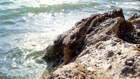 Beach-in-Greece,-foamy-waves-of-the-Ionian-Sea-crashing-against-the-rock