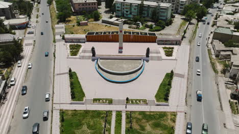 Tráfico-En-Las-Calles-Con-El-Monumento-Al-Parque-Pobedy-En-Istaravshan,-Tayikistán