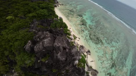 Fpv-drone-flying-on-a-Anse-Source-d'Argent-beach-in-Seychelles-on-an-Island-Mahe,-video-of-incredible-trees,-Seychelles-rocks,-seaside,-and-surrounding-Seychelles-landscapes