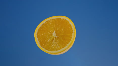 Close-up-of-Juicy-Orange-Half-on-a-Blue-Screen,-Loopable-Chroma-Key