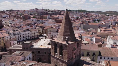 Iglesia-De-Santiago-El-Mayor-Aerial-View-Circling-Catholic-Church-Tower-Spire-In-Cáceres,-Spain