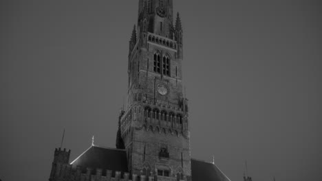 Tilt-Shot-of-Beffroi-on-Main-square-at-night-in-Bruges,-Belgium